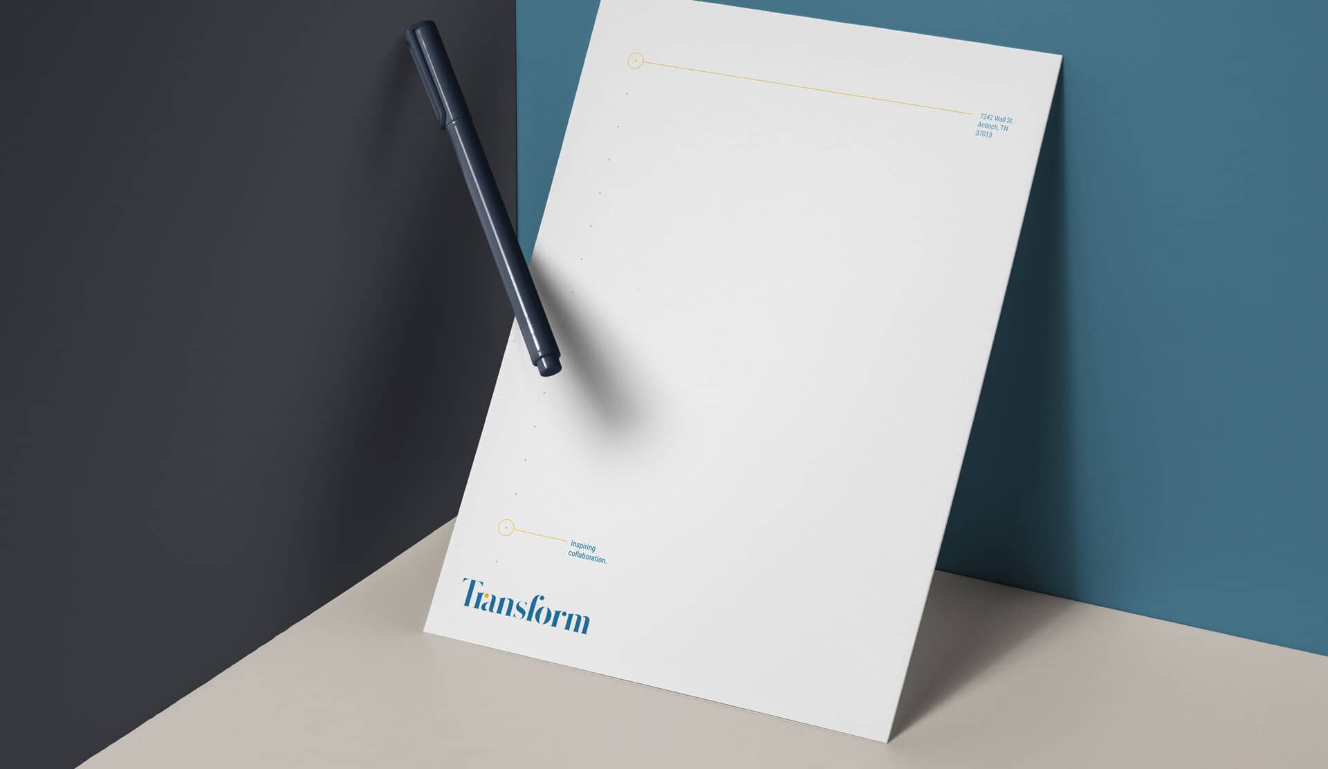 Transform letterhead design on thick paper resting on a blue background
